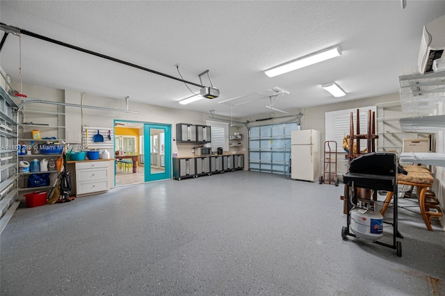 garage with freestanding refrigerator and a garage door opener