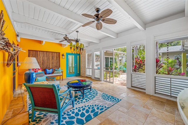 sunroom featuring healthy amount of natural light and beamed ceiling