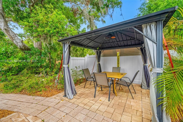 view of patio / terrace featuring a gazebo, fence, and outdoor dining space