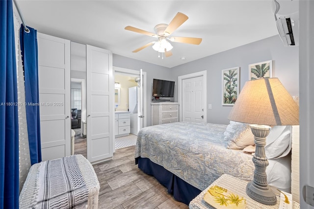bedroom with wood finished floors, a wall mounted air conditioner, and a ceiling fan