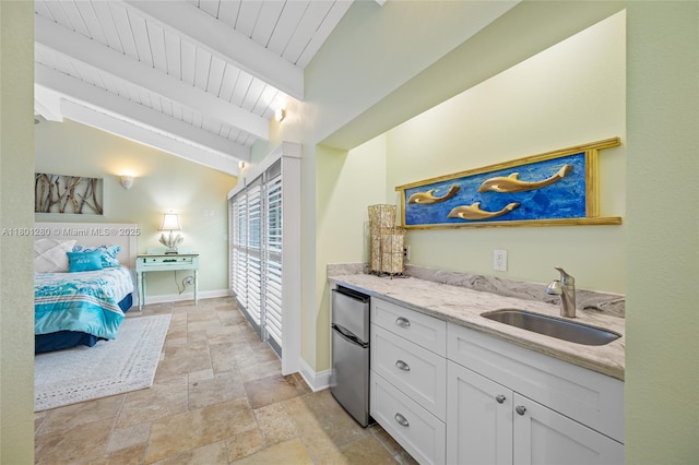 bar with fridge, a sink, stone tile flooring, baseboards, and wooden ceiling