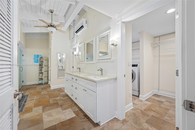 bathroom with stone tile floors, washer / dryer, an AC wall unit, ceiling fan, and beam ceiling