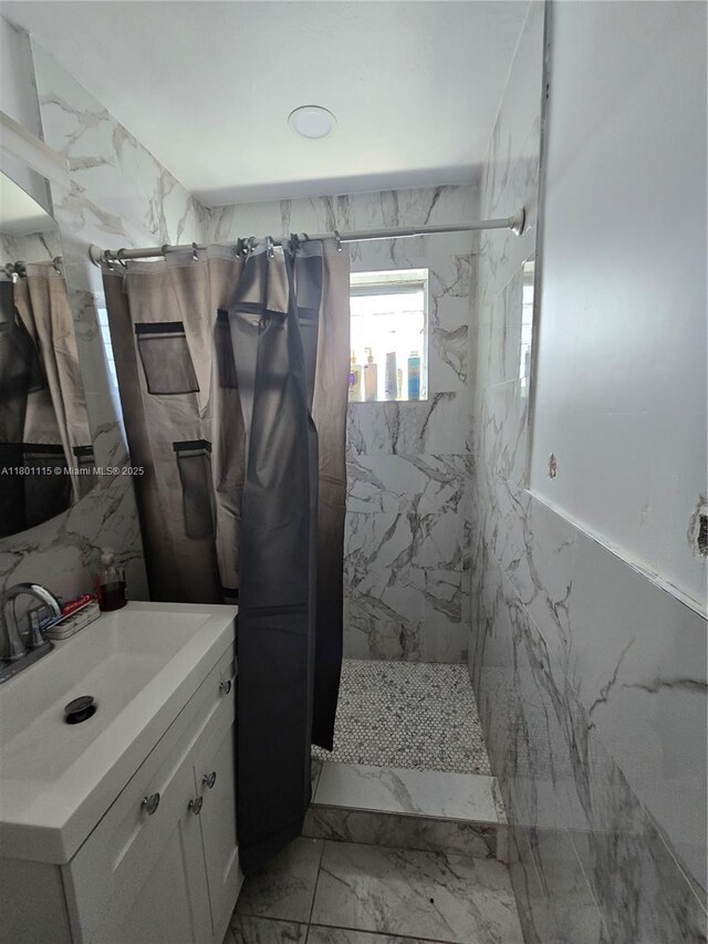 2414 Johnson St, Hollywood, FL 33020 - bathroom featuring marble look tiles, a marble finish shower, tile walls, and vanity