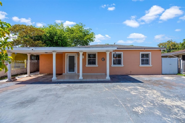 911 E 32nd St, Hialeah, FL 33013 - view of front of house with fence, covered porch, stucco siding, and a carport