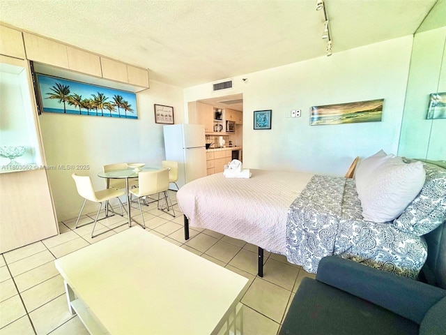 19201 Collins Ave Unit 606, Sunny Isles Beach, FL 33160 - bedroom featuring freestanding refrigerator, light tile patterned flooring, and rail lighting