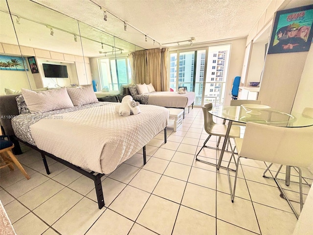 19201 Collins Ave Unit 606, Sunny Isles Beach, FL 33160 - bedroom with track lighting, light tile patterned flooring, and a textured ceiling