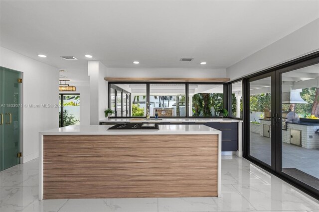 kitchen featuring french doors, modern cabinets, a center island, light marble finish flooring, and recessed lighting