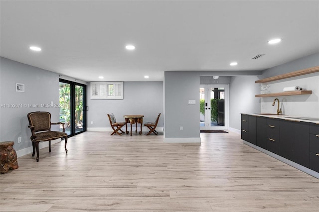 kitchen featuring french doors, a sink, open shelves, recessed lighting, and light wood-style flooring