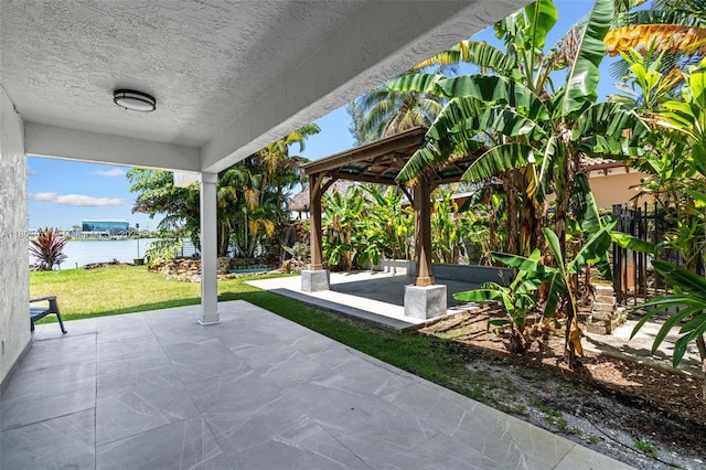 view of patio with a water view and a gazebo