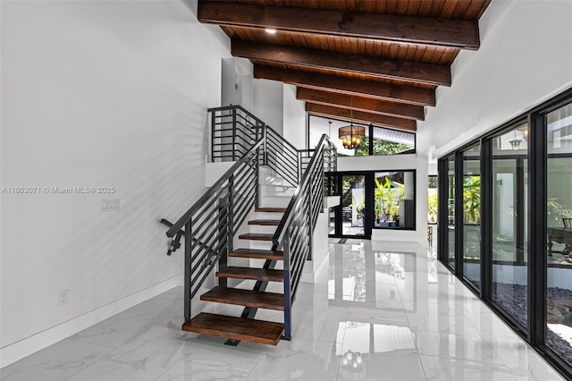 stairs featuring wooden ceiling, marble finish flooring, beam ceiling, a chandelier, and baseboards