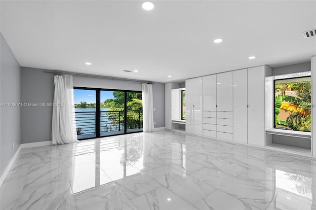 spare room with light marble finish floors, baseboards, and recessed lighting