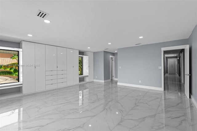 unfurnished living room with light marble finish flooring, recessed lighting, and baseboards