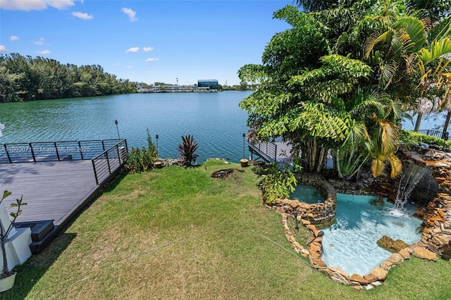dock area with a yard and a deck with water view