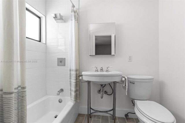 bathroom with toilet, shower / tub combo, baseboards, tile patterned floors, and a sink