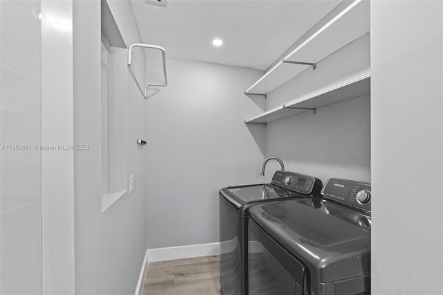 laundry area featuring washing machine and clothes dryer, baseboards, wood finished floors, and recessed lighting