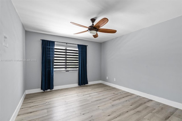 spare room with a ceiling fan, wood finished floors, and baseboards
