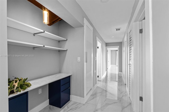 corridor with light marble finish floors and baseboards