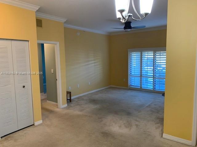 4907 Midtown Ln Unit 1113, Palm Beach Gardens, FL 33418 - unfurnished room with a chandelier, carpet flooring, ornamental molding, and baseboards