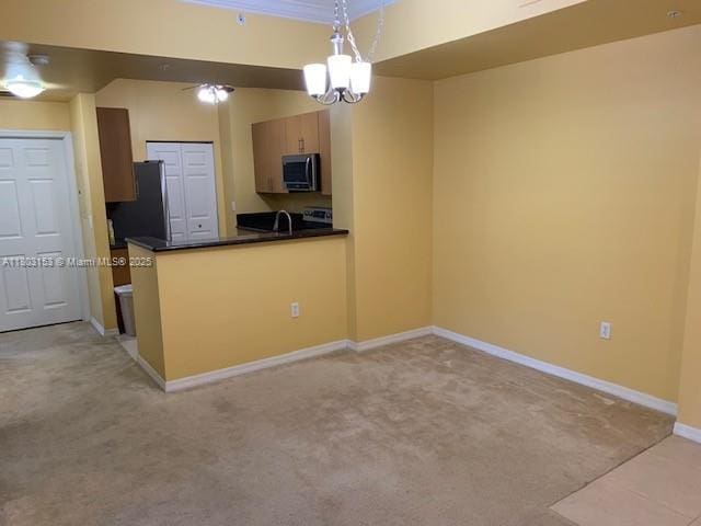 4907 Midtown Ln Unit 1113, Palm Beach Gardens, FL 33418 - kitchen with stainless steel appliances, light colored carpet, dark countertops, a peninsula, and pendant lighting