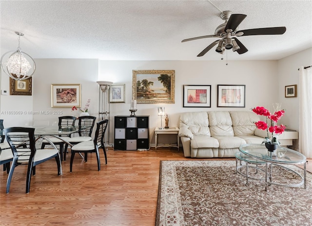 4330 Hillcrest Dr Unit 505, Hollywood, FL 33021 - living room with a textured ceiling, light wood-style flooring, ceiling fan, and a chandelier