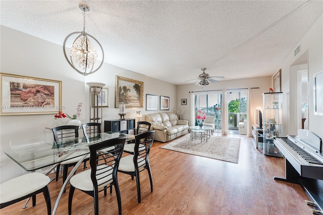 4330 Hillcrest Dr Unit 505, Hollywood, FL 33021 - dining space with a textured ceiling, wood finished floors, a ceiling fan, and a chandelier