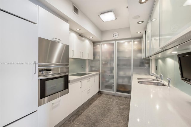 450 Alton Rd Unit 2303, Miami Beach, FL 33139 - kitchen with a sink, white cabinets, light countertops, recessed lighting, and black electric cooktop