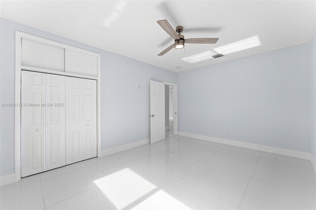 1998 NE 180th St, North Miami Beach, FL 33162 - unfurnished bedroom with a closet, light tile patterned flooring, baseboards, and a ceiling fan