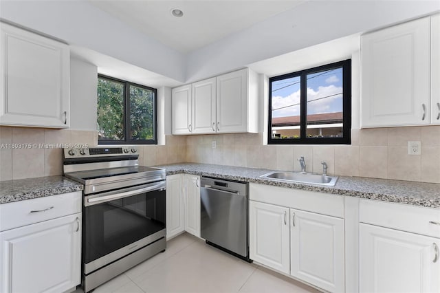 1998 NE 180th St, North Miami Beach, FL 33162 - kitchen featuring appliances with stainless steel finishes, a sink, white cabinets, and backsplash