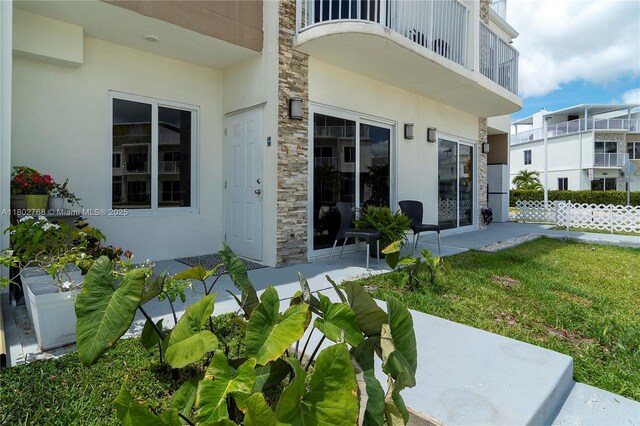 13949 SW 259th Way, Homestead, FL 33032 - property entrance featuring stone siding, stucco siding, fence, and a patio area