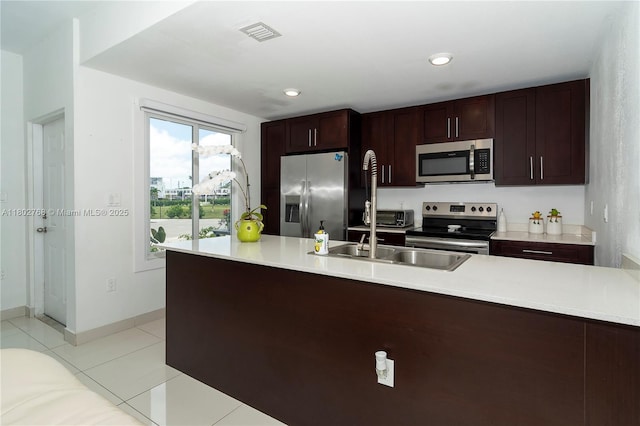 13949 SW 259th Way, Homestead, FL 33032 - kitchen featuring stainless steel appliances, a sink, light countertops, light tile patterned floors, and recessed lighting