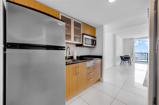 1750 N Bayshore Dr Unit 3308, Miami, FL 33132 - kitchen featuring stainless steel appliances, a sink, dark countertops, light tile patterned floors, and glass insert cabinets