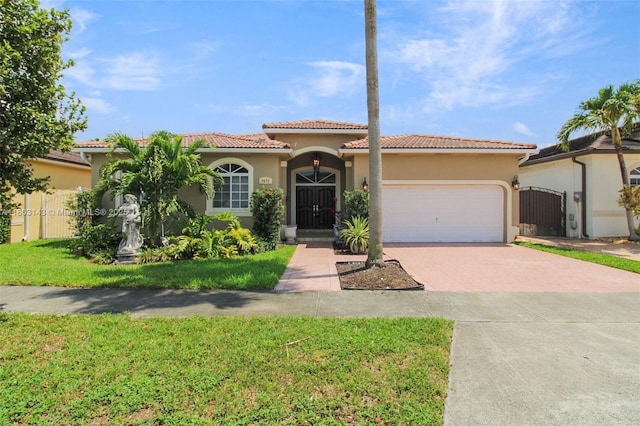 9072 NW 145th St, Miami Lakes, FL 33018 - mediterranean / spanish-style home with driveway, stucco siding, an attached garage, and a tiled roof