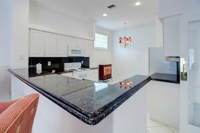 9072 NW 145th St, Miami Lakes, FL 33018 - kitchen with white appliances, dark stone countertops, decorative backsplash, white cabinets, and a chandelier