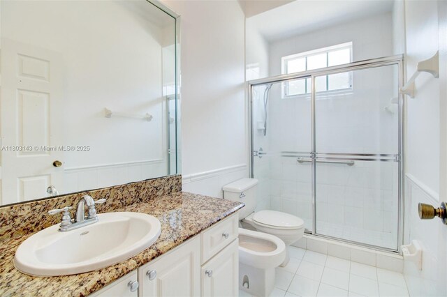 9072 NW 145th St, Miami Lakes, FL 33018 - bathroom with a bidet, toilet, a stall shower, vanity, and tile patterned floors