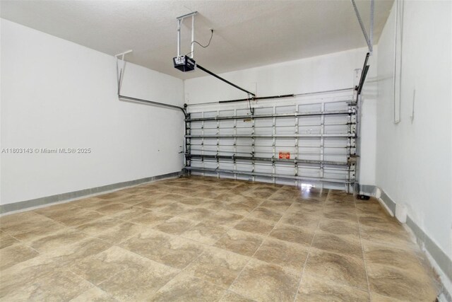 9072 NW 145th St, Miami Lakes, FL 33018 - garage featuring a garage door opener and baseboards