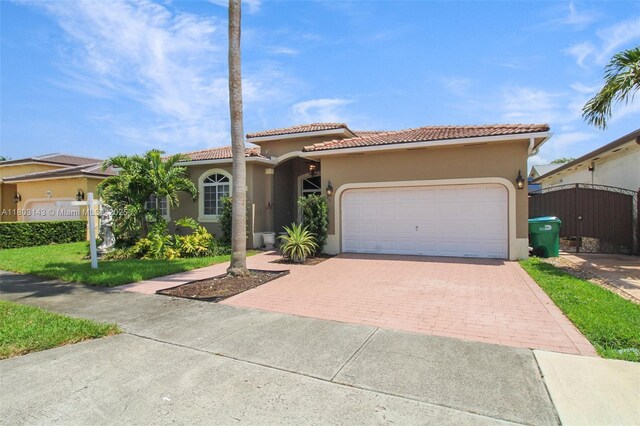 9072 NW 145th St, Miami Lakes, FL 33018 - mediterranean / spanish-style home featuring decorative driveway, stucco siding, an attached garage, and a tile roof