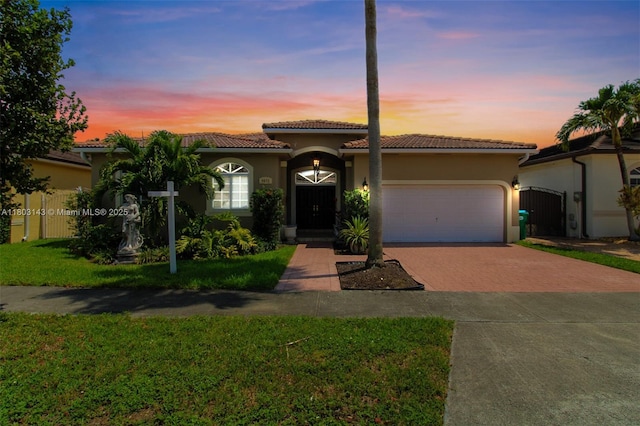 9072 NW 145th St, Miami Lakes, FL 33018 - mediterranean / spanish home featuring decorative driveway, stucco siding, an attached garage, and a tile roof