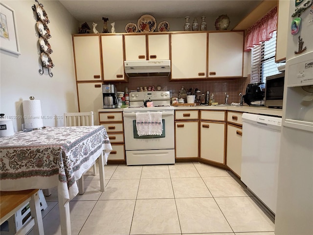 2903 S Carambola Cir S Unit 2094, Coconut Creek, FL 33066 - kitchen featuring white appliances, under cabinet range hood, light countertops, and backsplash