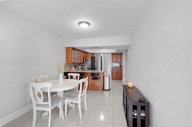 857 W 37th St, Hialeah, FL 33012 - dining space with light tile patterned flooring and baseboards