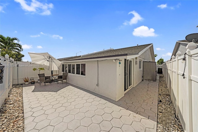 857 W 37th St, Hialeah, FL 33012 - back of property with a patio area, a fenced backyard, stucco siding, and roof with shingles