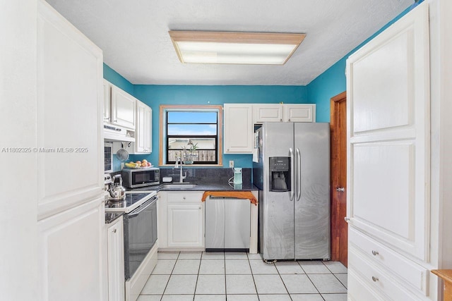 17331 SW 119th Ave, Miami, FL 33177 - kitchen featuring appliances with stainless steel finishes, dark countertops, white cabinetry, exhaust hood, and light tile patterned floors