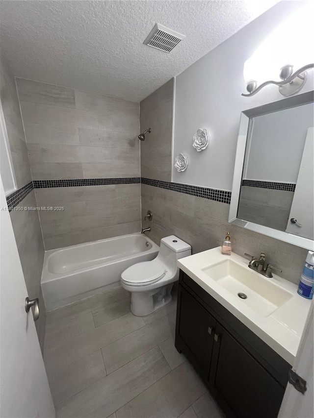 6014 SW 162nd Pl, Miami, FL 33193 - bathroom featuring shower / bath combination, vanity, a textured ceiling, and tile walls