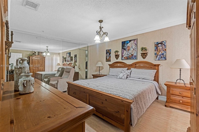 13338 SW 8th Ln, Miami, FL 33184 - bedroom with light wood-style floors, ornamental molding, a chandelier, and a textured ceiling