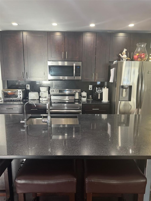 111 SW 24th Ave, Miami, FL 33135 - kitchen with appliances with stainless steel finishes, a kitchen breakfast bar, backsplash, and recessed lighting