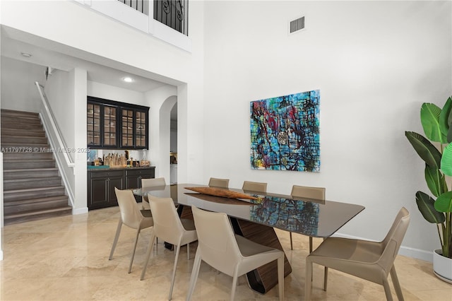 3837 E Coquina Way, Weston, FL 33332 - dining space featuring bar area, arched walkways, stairs, baseboards, and a high ceiling
