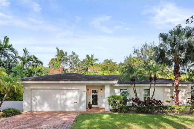 6809 Mentone St, Coral Gables, FL 33146 - ranch-style home with a garage, decorative driveway, stucco siding, and a front lawn