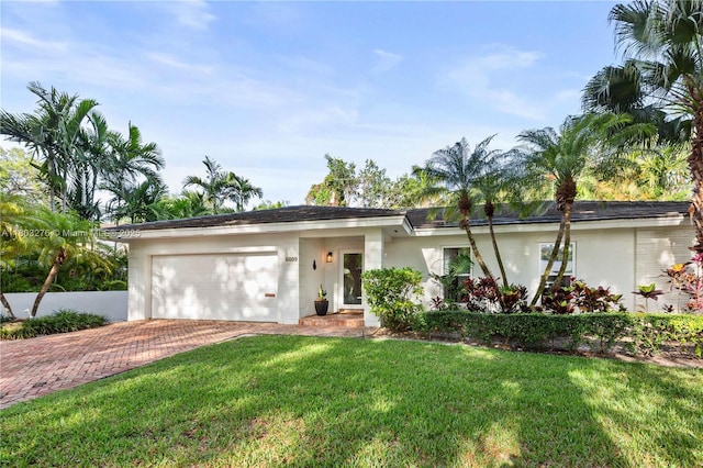 6809 Mentone St, Coral Gables, FL 33146 - ranch-style home with decorative driveway, stucco siding, an attached garage, and a front lawn