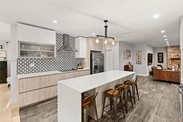6809 Mentone St, Coral Gables, FL 33146 - kitchen with stainless steel fridge, wall chimney range hood, modern cabinets, black electric cooktop, and recessed lighting
