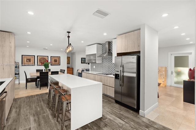 6809 Mentone St, Coral Gables, FL 33146 - kitchen featuring appliances with stainless steel finishes, modern cabinets, wall chimney exhaust hood, a kitchen island, and light brown cabinets