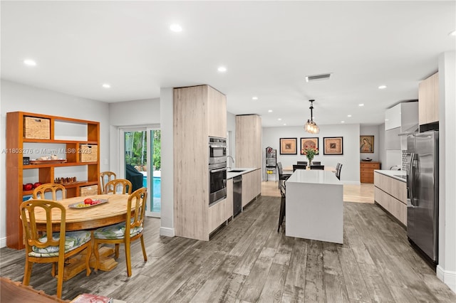 6809 Mentone St, Coral Gables, FL 33146 - kitchen with modern cabinets, stainless steel fridge with ice dispenser, a kitchen island, light countertops, and wood finished floors